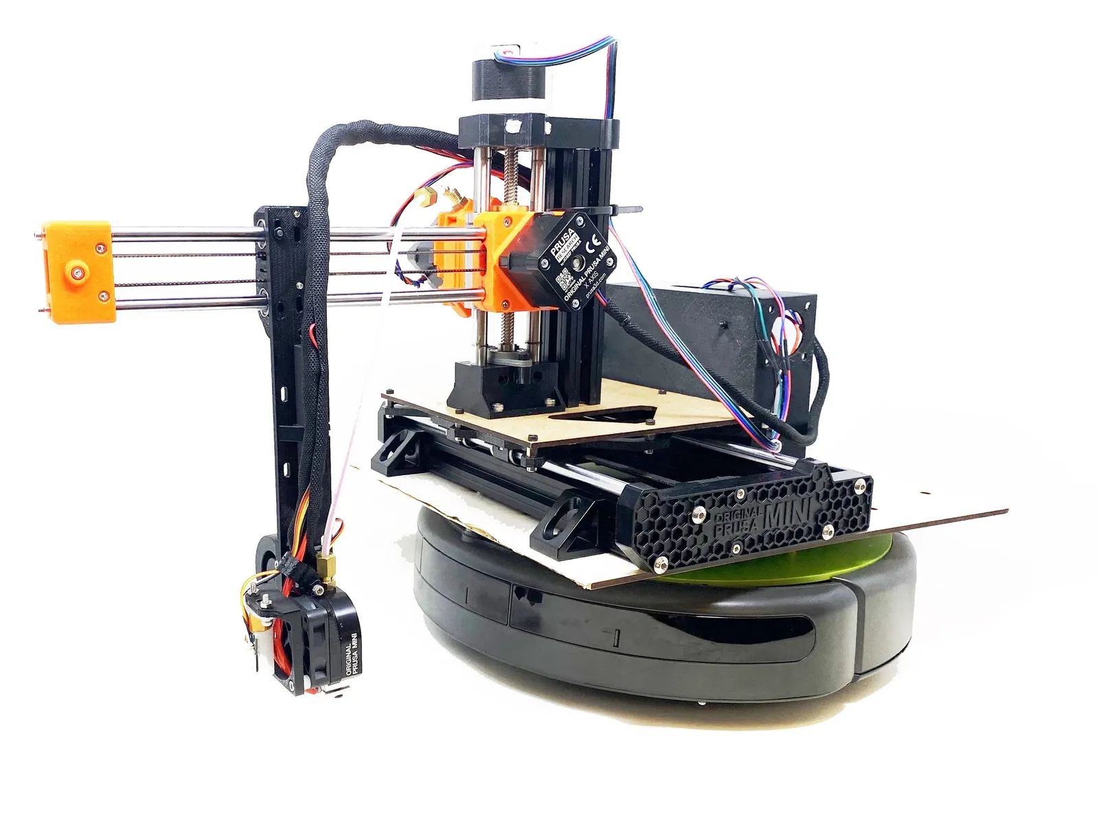 Photo of the MobiPrint system consisting of a 3D printer with a modified attachment that reaches to the floor, a robotic vacuum base, and wireless controller.