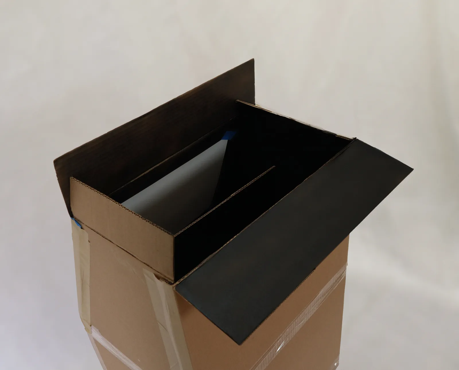 Photo showing the inside of the cardboard mockup which shows an all-black interior with a sheet to expose the images.